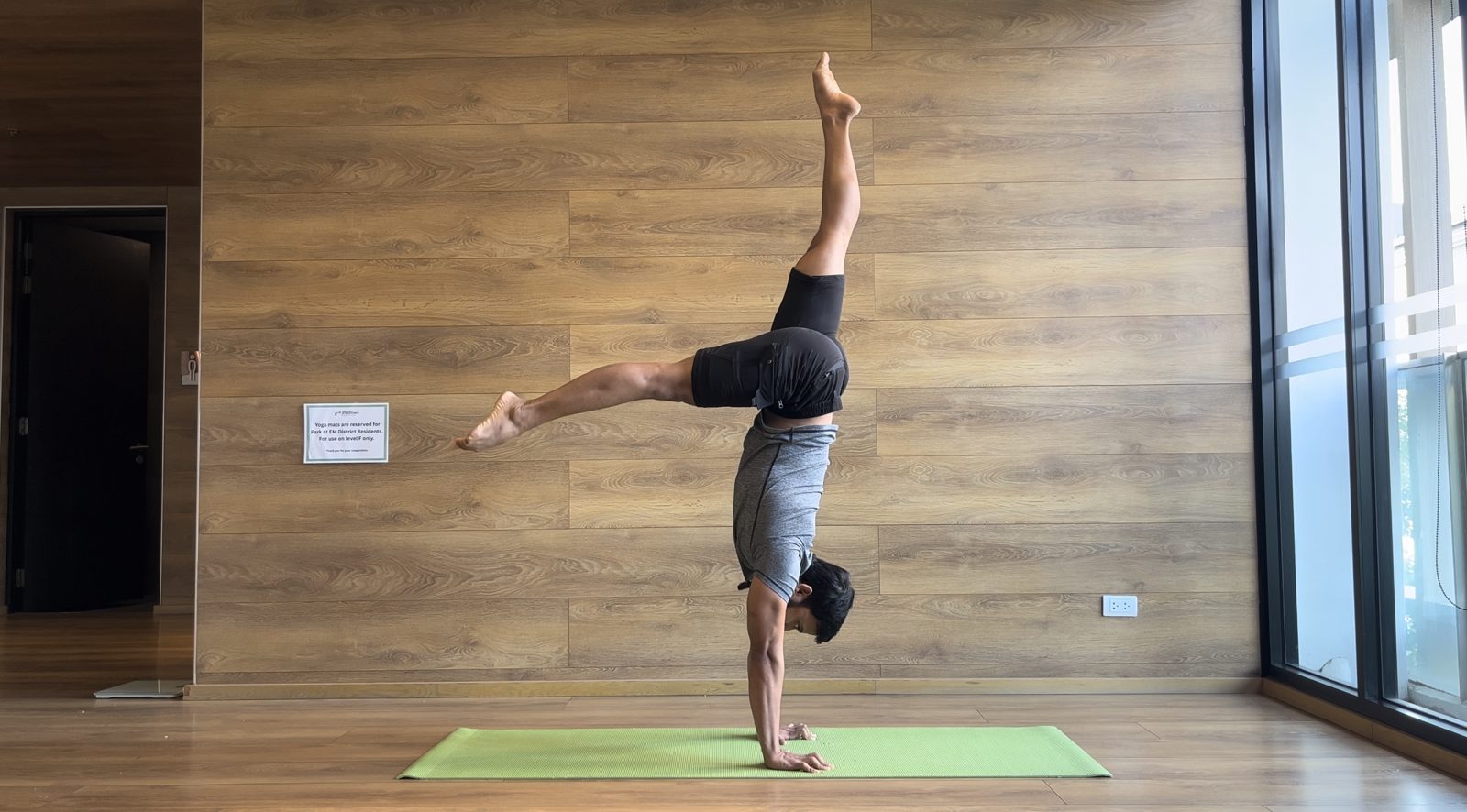 Devesh in a split handstand on the green mat